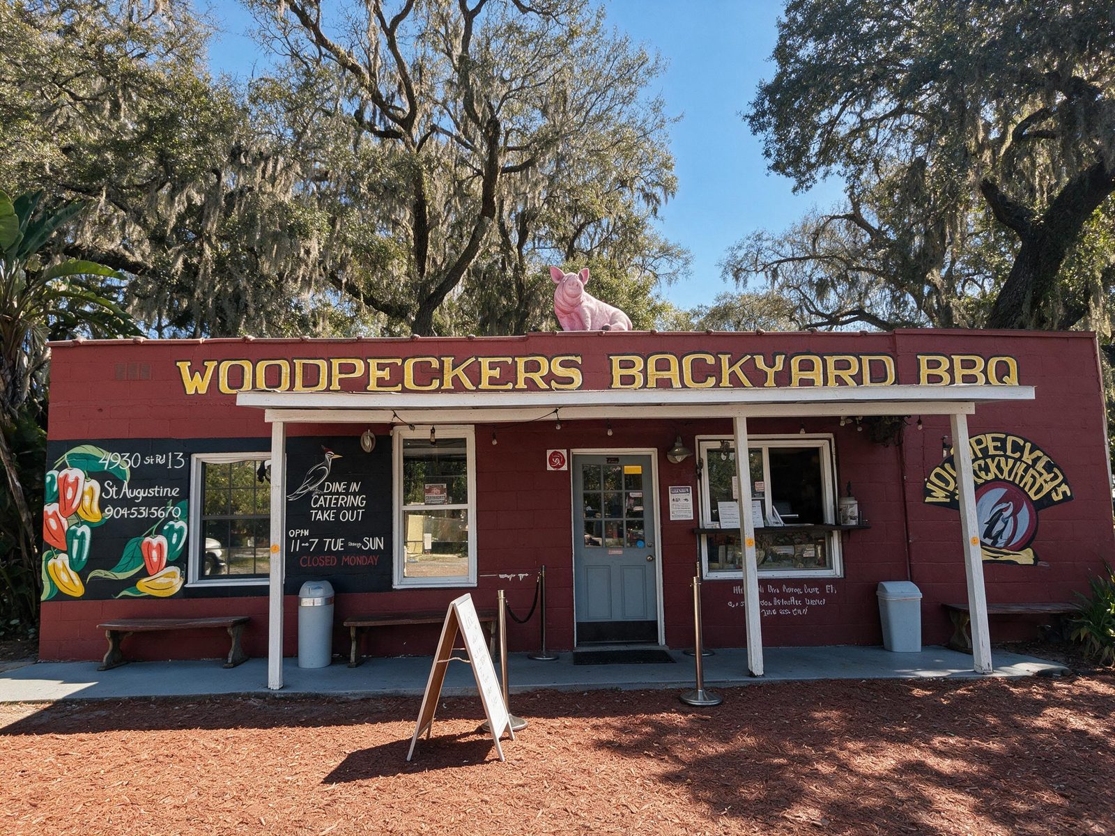 Woodpeckers Backyard BBQ storefront at 4930 State Road 13, St. Augustine, FL, with the backyard patio and pig statue on the roof